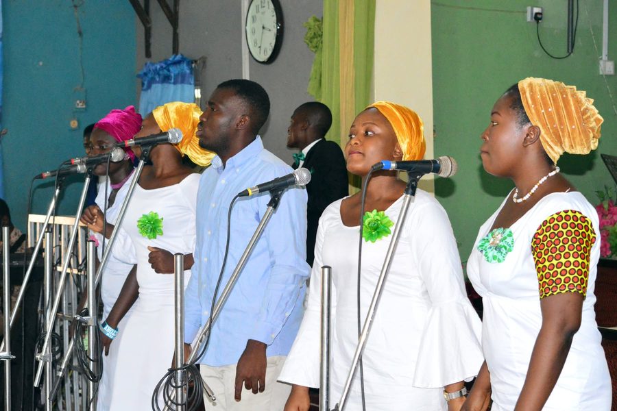 Choir leading worship in white and green